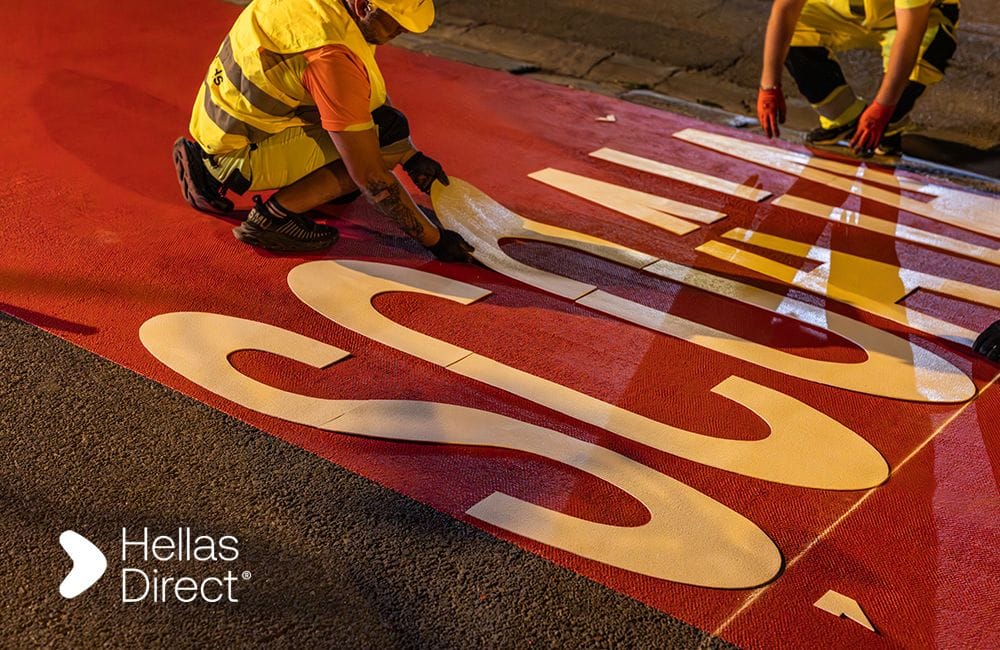The Safe Roads project crew fixing the word scoala on a crosswalk